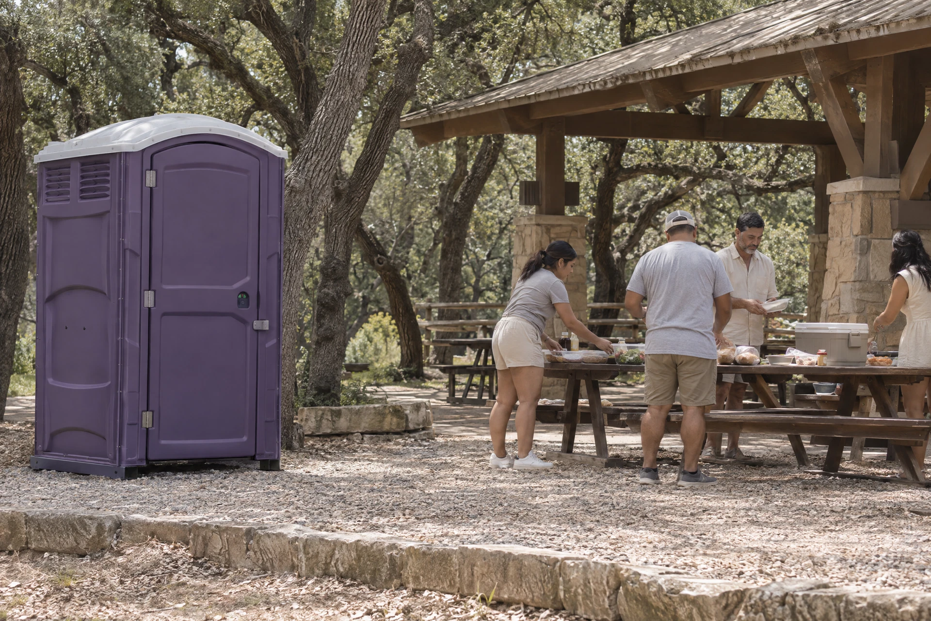 Portable restroom beside a family reunion picnic pavilion